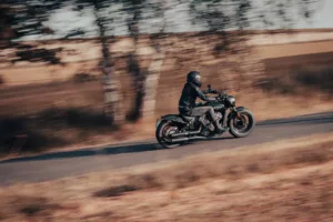 a man riding a motorcycle down a country road